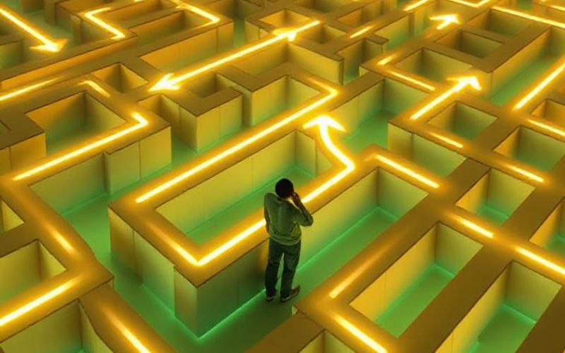 3D labyrinth with glowing paths and person thinking